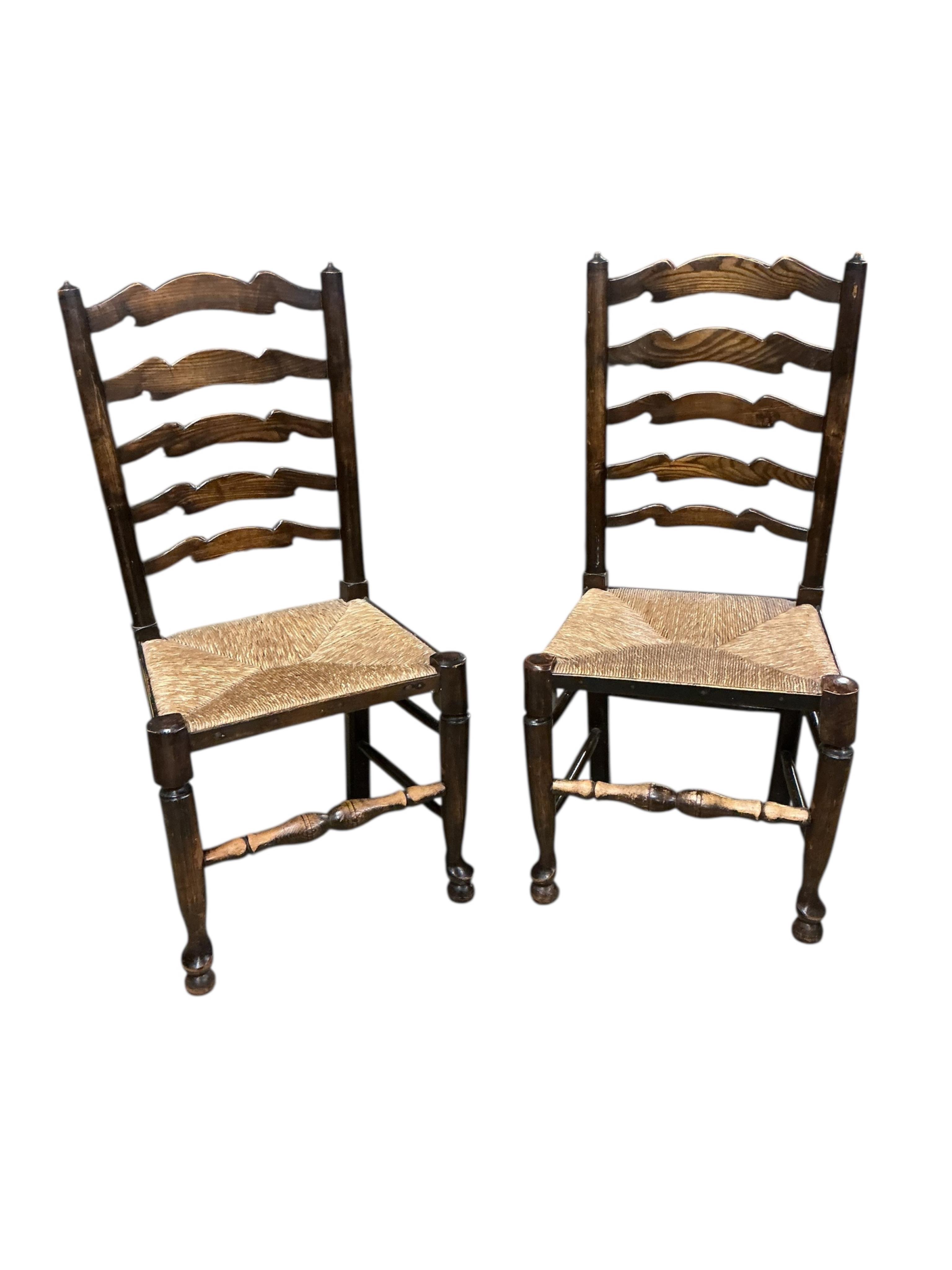 A set of six Lancashire style elm and beech rush seat ladderback dining chairs, two with arms